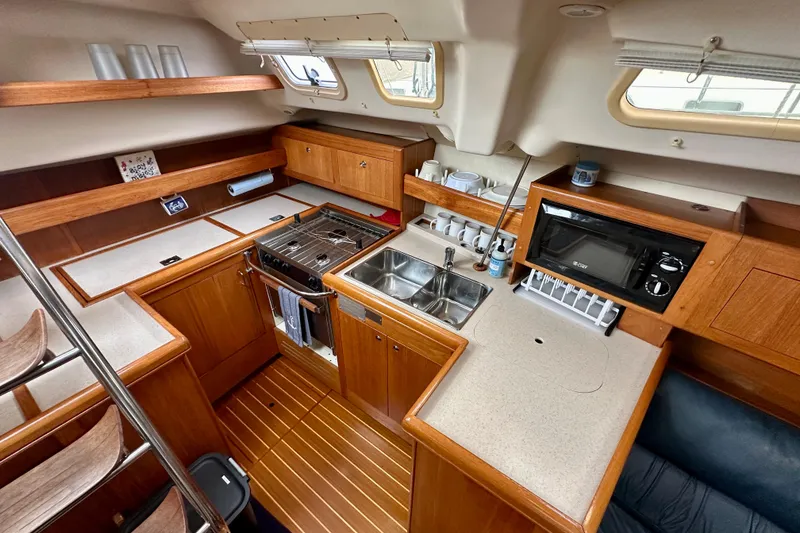 Slide: The Image of Interior of 2002 Hunter Passage 420 yacht kitchen with wood cabinetry and modern appliances. - 24