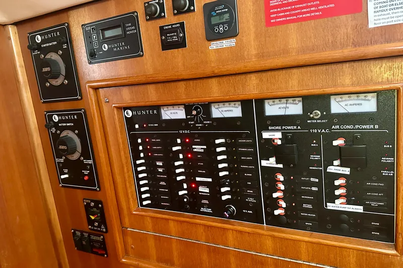 Slide: The Image of Control panel of a 2002 Hunter Passage 420 yacht, featuring electrical switches and gauges. - 25