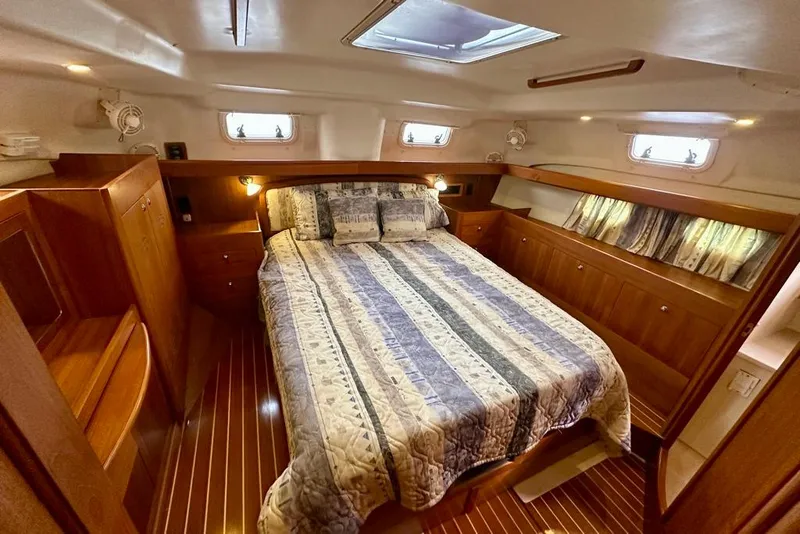 Slide: The Image of Cozy cabin interior of 2002 Hunter Passage 420 sailboat with wood finish and bed. - 28