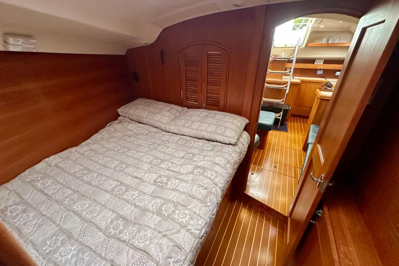 Slide: The Image of Cozy cabin interior of 2002 Hunter Passage 420 sailboat with wooden finish and bed. - 29