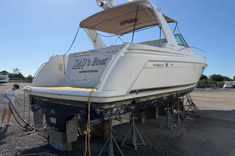 Slide: The Image of 2000 Formula 41 Performance Cruiser on stands, with a person handling ropes nearby. - 2