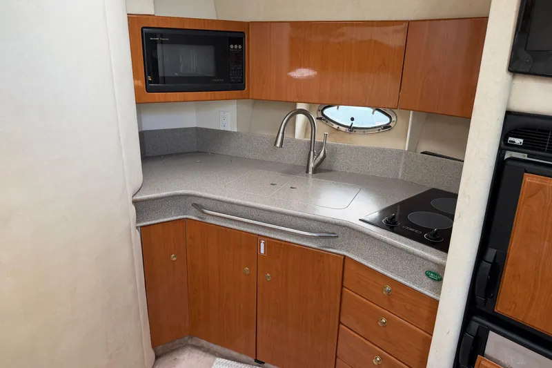 Slide: The Image of Compact kitchen in a 2000 Formula 41 Performance Cruiser with wood cabinets and modern appliances. - 9