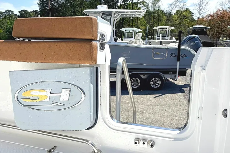 Slide: The Image of Seahunt Ultra 305 CB 2026 boat with logo, parked on a trailer in a marina. - 3