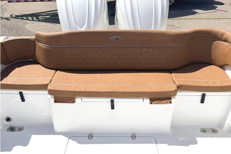 Slide: The Image of 2026 Seahunt Ultra 305 CB boat with tan cushioned seating and white exterior. - 4