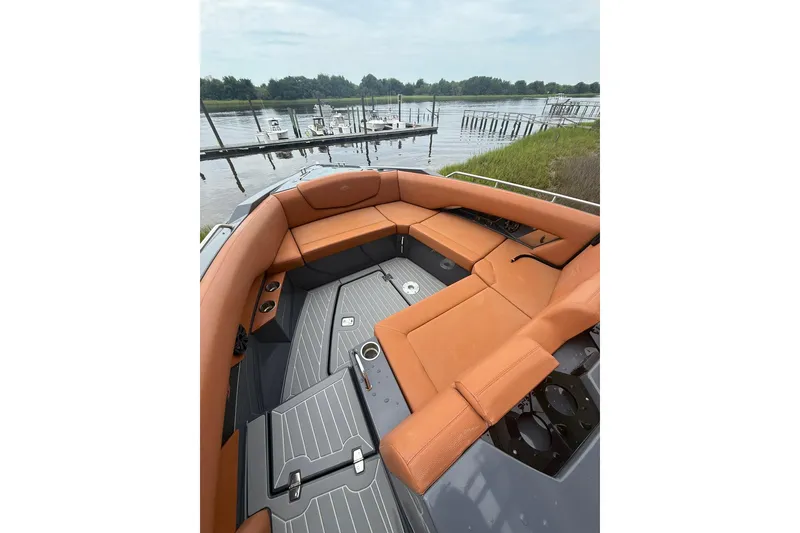 Slide: The Image of 2021 Cruisers Yachts 338 Bow Rider with orange seating, docked by a serene lake. - 10