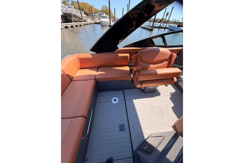 Slide: The Image of 2021 Cruisers Yachts 338 Bow Rider interior with orange seating, docked by the water. - 12