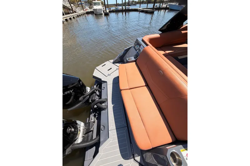 Slide: The Image of 2021 Cruisers Yachts 338 Bow Rider with orange seating, docked by the water. - 13