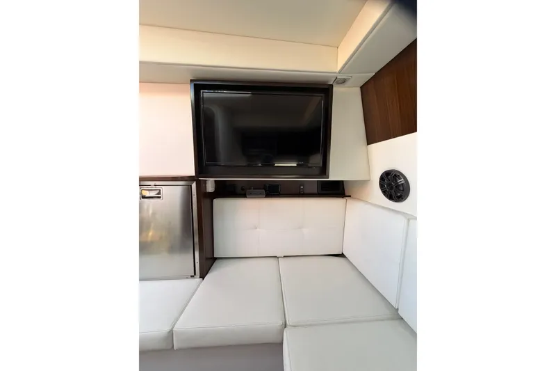 Slide: The Image of Interior of 2021 Cruisers Yachts 338 Bow Rider with TV and white seating. - 18