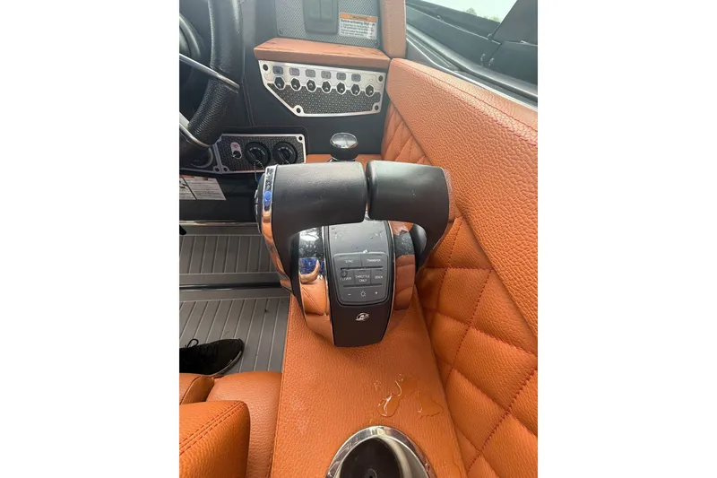 Slide: The Image of 2021 Cruisers Yachts 338 Bow Rider helm with orange leather and control panel. - 24