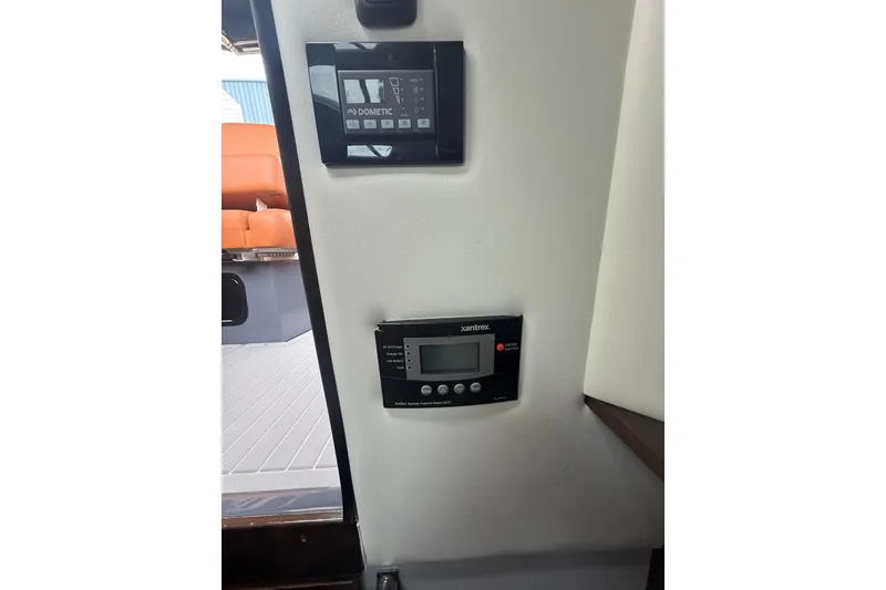 Slide: The Image of 2021 Cruisers Yachts 338 Bow Rider interior controls, featuring Dometic and Xantrex panels. - 26