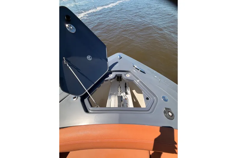 Slide: The Image of 2021 Cruisers Yachts 338 Bow Rider with open storage compartment on calm water. - 29