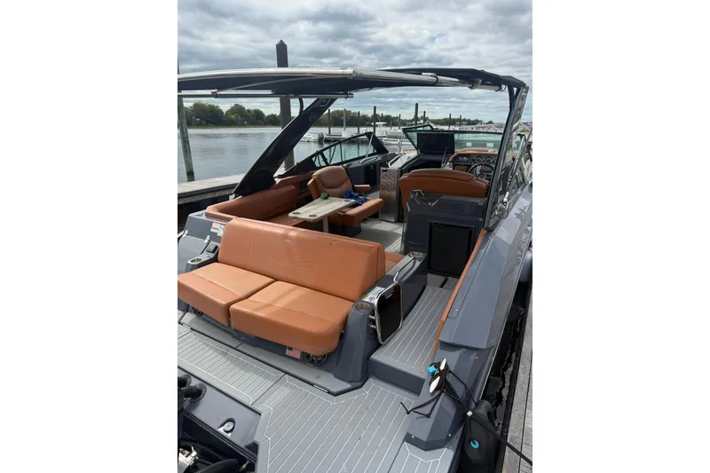 Slide: The Image of 2021 Cruisers Yachts 338 Bow Rider with tan seating, docked by a river. - 7