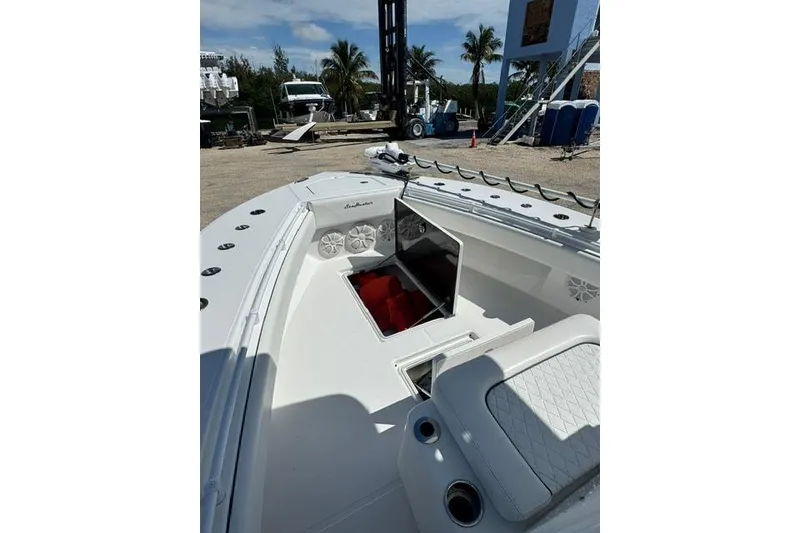 Slide: The Image of 2022 SeaHunter 28 Floridian boat interior with open storage compartment, docked outdoors. - 11