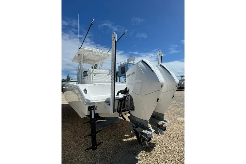 Slide: The Image of 2022 SeaHunter 28 Floridian boat with dual Mercury outboard engines, parked on gravel. - 13