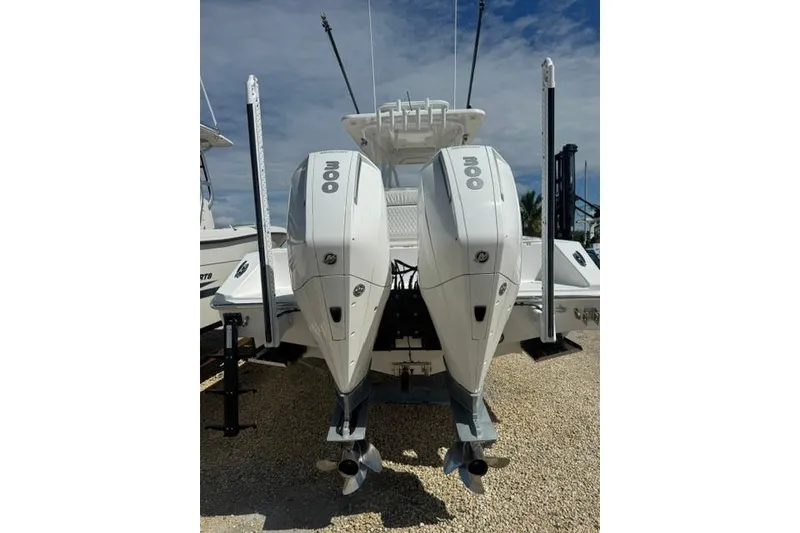 Slide: The Image of 2022 SeaHunter 28 Floridian boat with dual 300 horsepower engines, parked on gravel. - 14