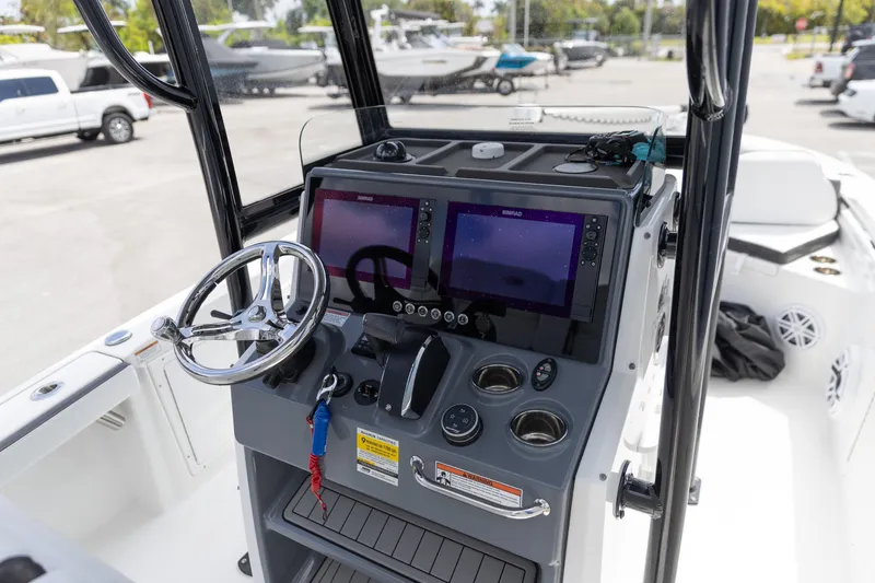Slide: The Image of 2023 Crevalle 26 HCO boat console with dual screens and steering wheel. - 2