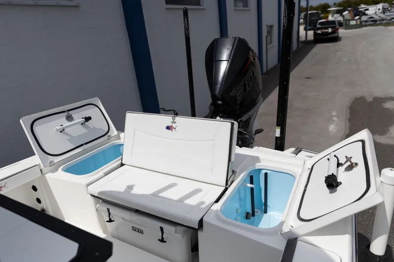 Slide: The Image of 2023 Crevalle 26 HCO boat with open storage compartments and outboard motor. - 5