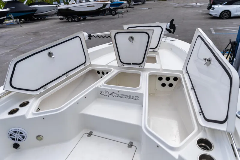 Slide: The Image of 2023 Crevalle 26 HCO boat with open storage compartments in a marina setting. - 8