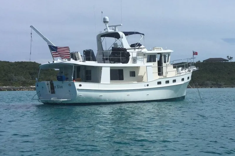 Slide: The Image of Kadey-Krogen 48 AE 2011 yacht anchored in clear blue water with American flag. - 11