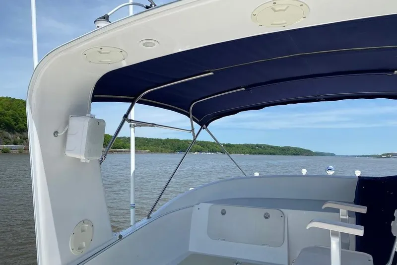 Slide: The Image of 2011 Kadey-Krogen 48 AE boat deck with blue canopy on a calm river. - 22