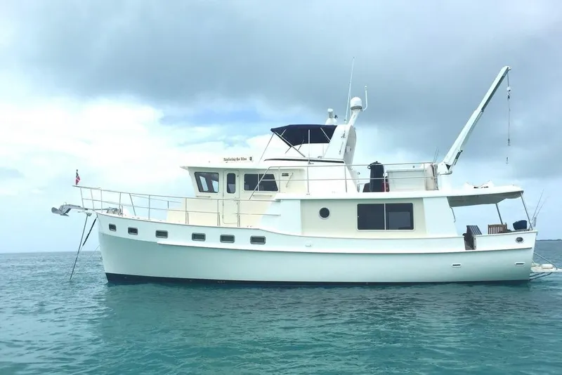 Slide: The Image of 2011 Kadey-Krogen 48 AE yacht anchored on calm blue waters under cloudy skies. - 4