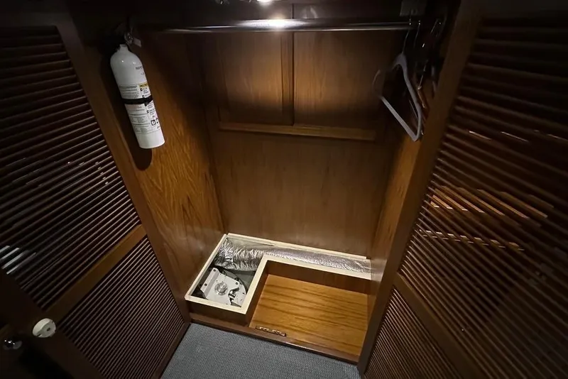 Slide: The Image of Wooden closet interior on a 2011 Kadey-Krogen 48 AE yacht, featuring a fire extinguisher. - 44