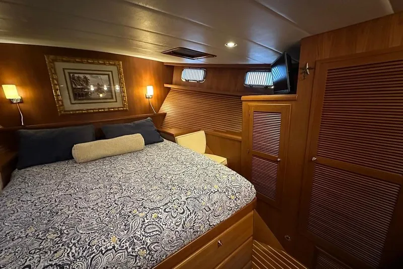Slide: The Image of Luxurious 2011 Kadey-Krogen 48 AE yacht bedroom with elegant wood paneling and cozy bedding. - 52