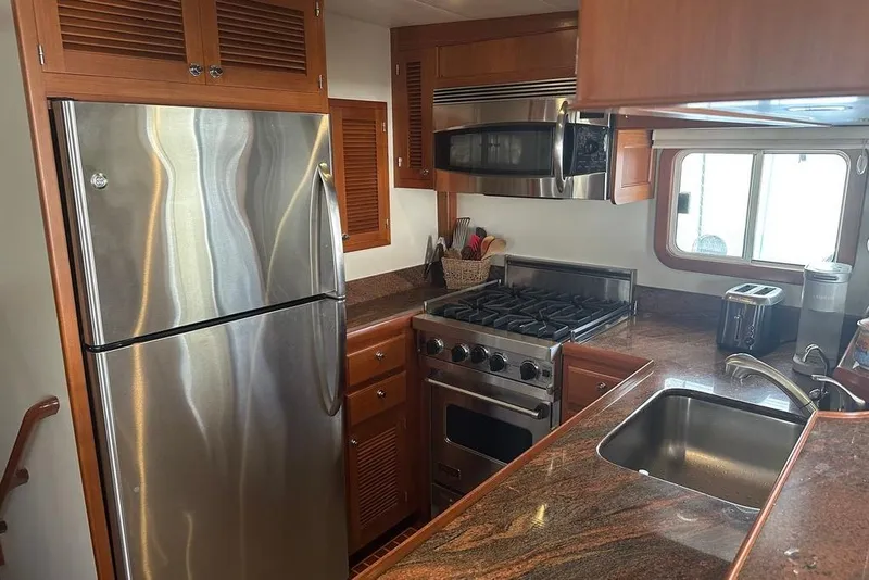 Slide: The Image of Luxurious 2011 Kadey-Krogen 48 AE yacht kitchen with stainless steel appliances and wooden cabinetry. - 57
