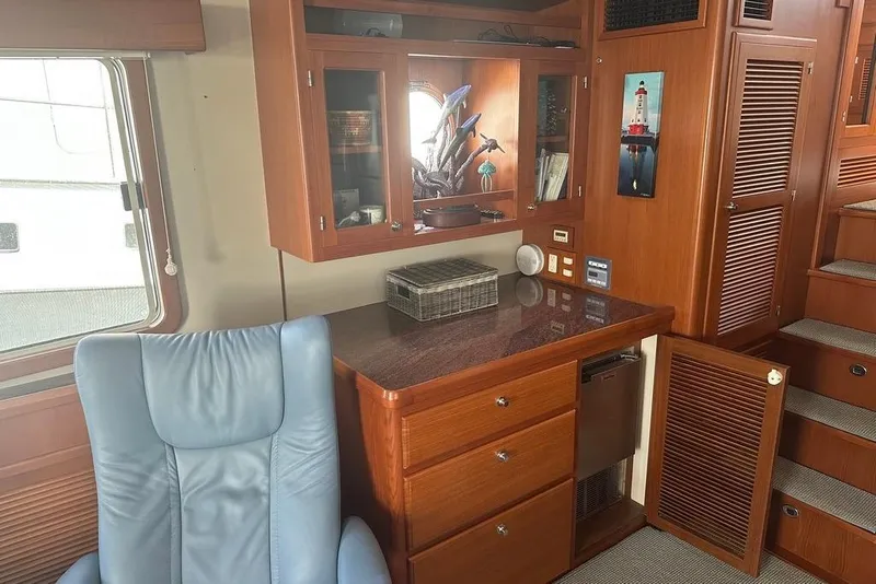 Slide: The Image of Luxurious interior of 2011 Kadey-Krogen 48 AE yacht with wooden cabinetry and blue chair. - 58