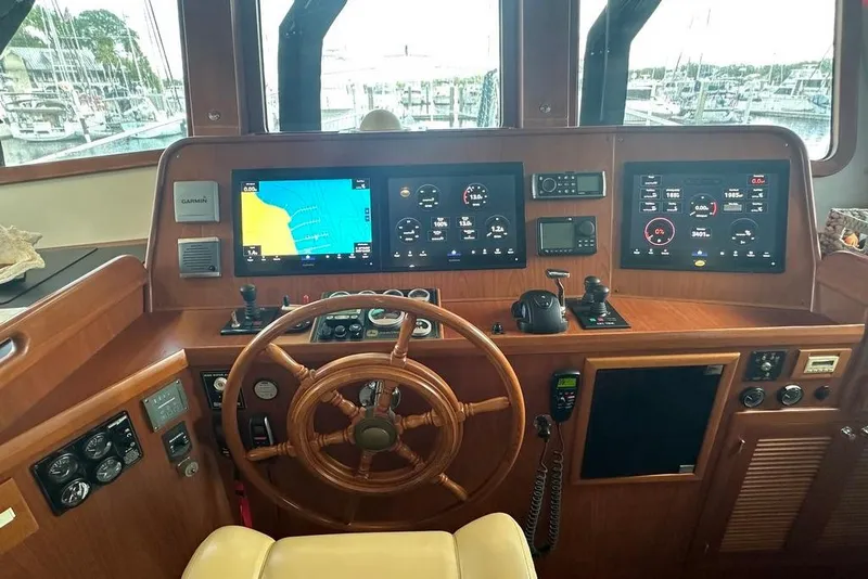 Slide: The Image of Pilothouse of 2011 Kadey-Krogen 48 AE with navigation screens and wooden steering wheel. - 74