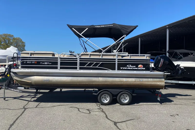 The Image of 2021 Sun Tracker Party Barge 22 DLX pontoon boat on trailer, parked outdoors. - 0
