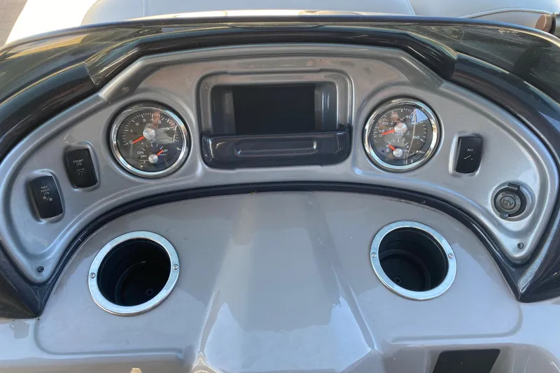 Slide: The Image of Dashboard of a 2021 Sun Tracker Party Barge 22 DLX with gauges and cup holders. - 12