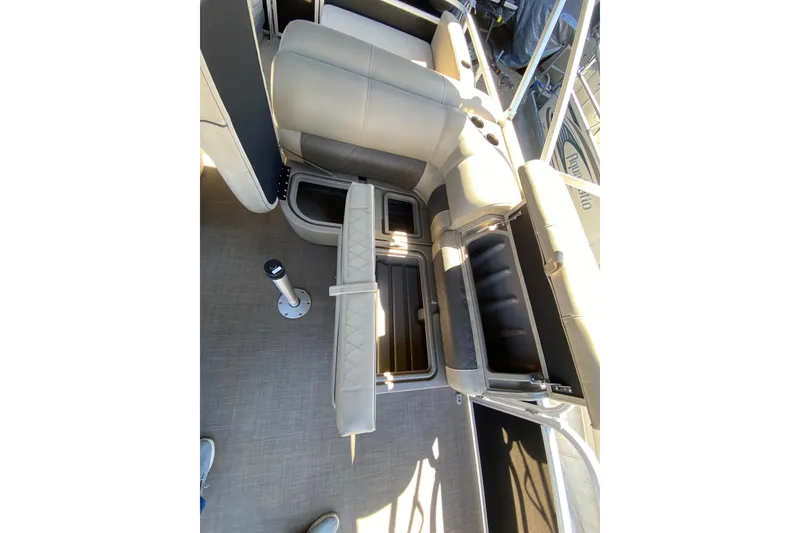 Slide: The Image of 2021 Sun Tracker Party Barge 22 DLX interior seating with storage compartments open. - 16