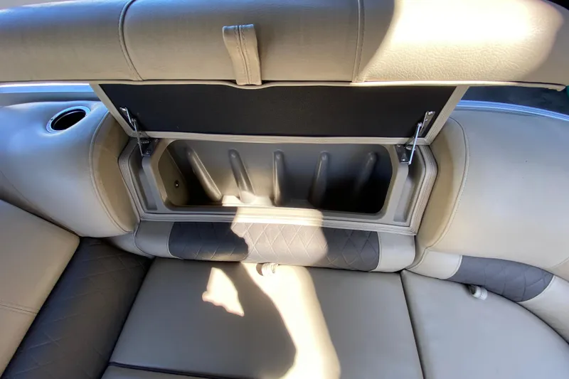 Slide: The Image of Sun Tracker Party Barge 22 DLX 2021 storage compartment with open lid and cup holder. - 17