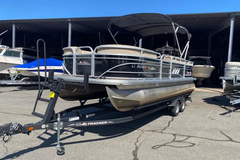 Slide: The Image of 2021 Sun Tracker Party Barge 22 DLX pontoon boat on trailer in marina. - 2