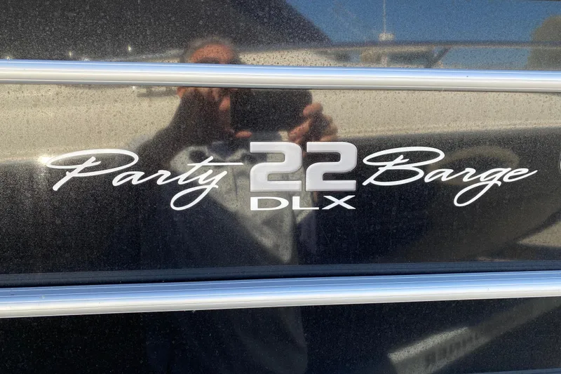 Slide: The Image of 2021 Sun Tracker Party Barge 22 DLX logo on a sleek black surface. - 20