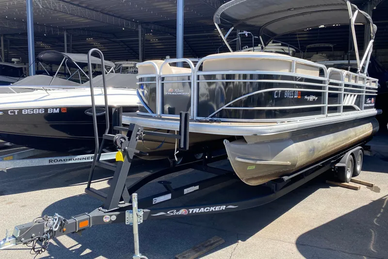 Slide: The Image of 2021 Sun Tracker Party Barge 22 DLX pontoon boat on trailer in storage facility. - 3