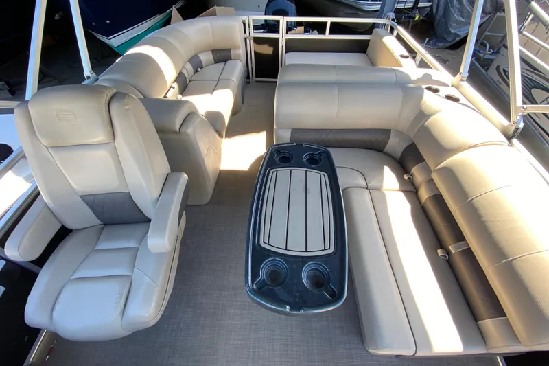 Slide: The Image of 2021 Sun Tracker Party Barge 22 DLX interior with plush seating and table. - 6