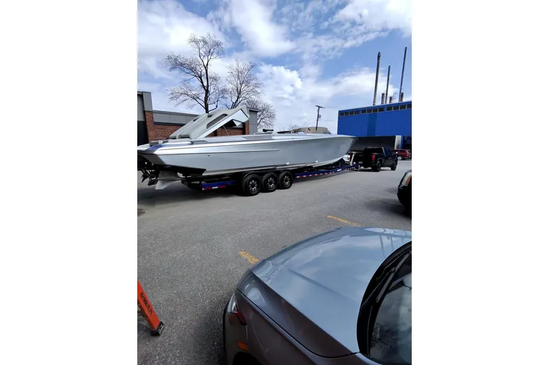Slide: The Image of 2017 Monte Carlo 420 boat on trailer, parked in industrial area under cloudy sky. - 11