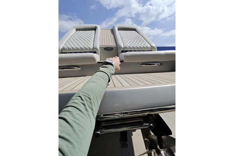 Slide: The Image of Arm reaching towards Monte Carlo 420 boat seats, 2017 model, under a blue sky. - 27