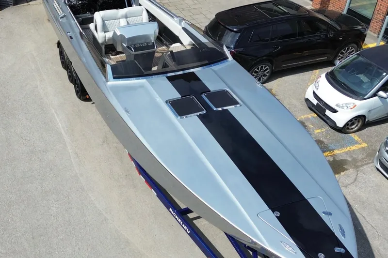 Slide: The Image of 2017 Monte Carlo 420 boat with sleek design, parked near cars. - 4