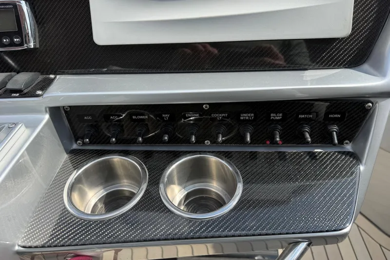 Slide: The Image of Control panel of a 2017 Monte Carlo 420 boat with switches and cup holders. - 47