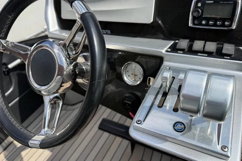 Slide: The Image of Steering wheel and controls of a 2017 Monte Carlo 420 boat cockpit. - 48