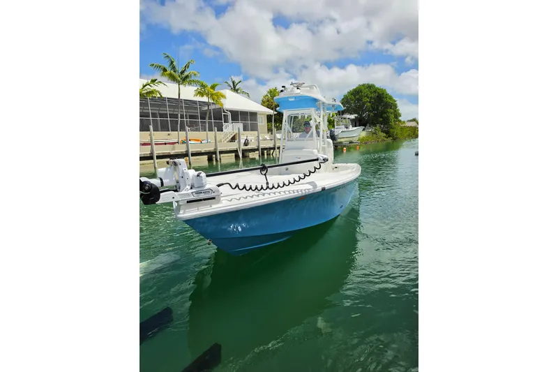 Slide: The Image of 2025 SeaVee 270Z boat docked in a tropical marina with palm trees. - 14