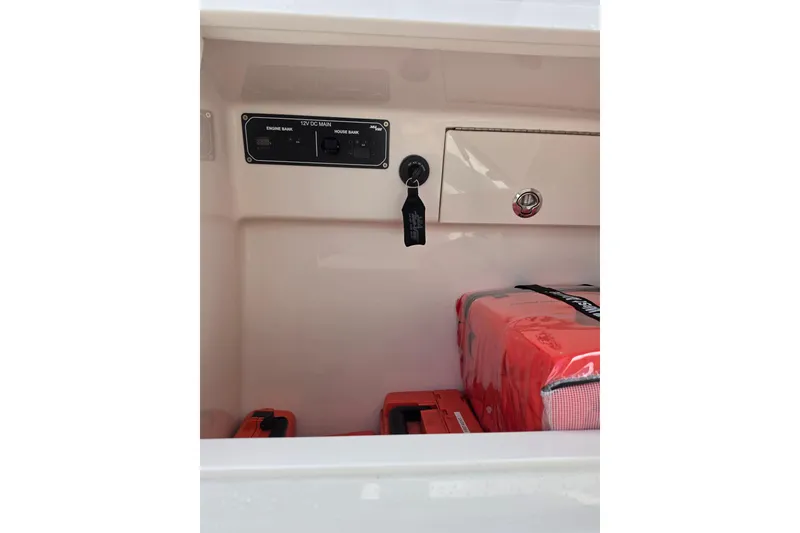 Slide: The Image of Interior view of 2025 SeaVee 270Z boat compartment with electrical panel and safety equipment. - 16