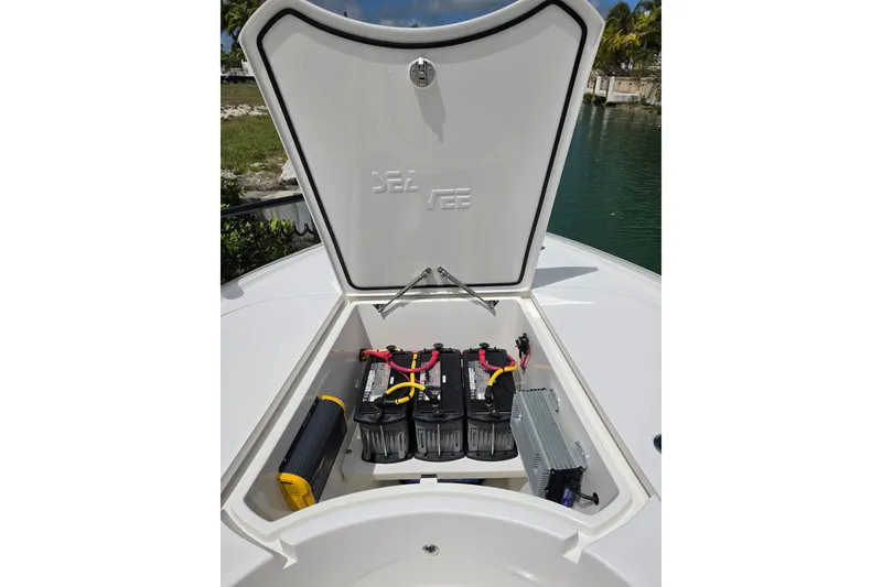 Slide: The Image of 2025 SeaVee 270Z boat battery compartment with open hatch, showcasing marine batteries. - 17
