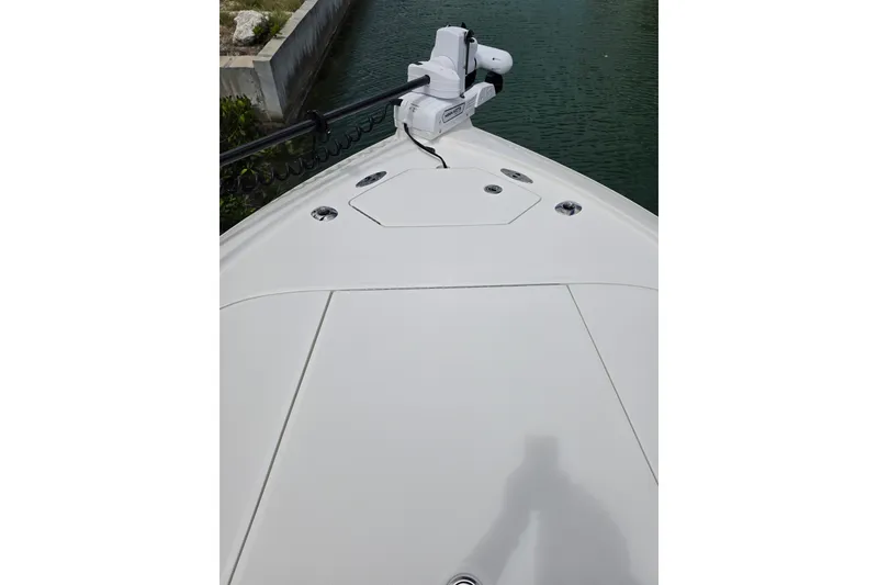 Slide: The Image of Bow view of 2025 SeaVee 270Z boat with trolling motor, docked in calm water. - 18