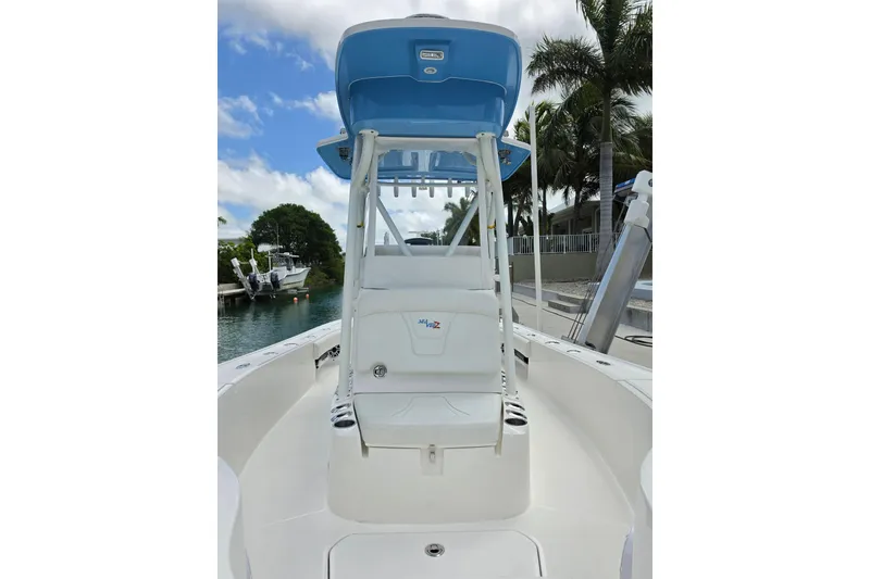 Slide: The Image of 2025 SeaVee 270Z boat with blue canopy, docked near palm trees and waterway. - 5