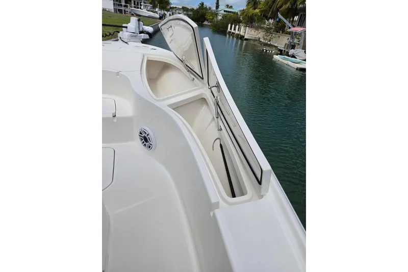 Slide: The Image of 2025 SeaVee 270Z boat with open storage compartment, docked by a serene waterway. - 6