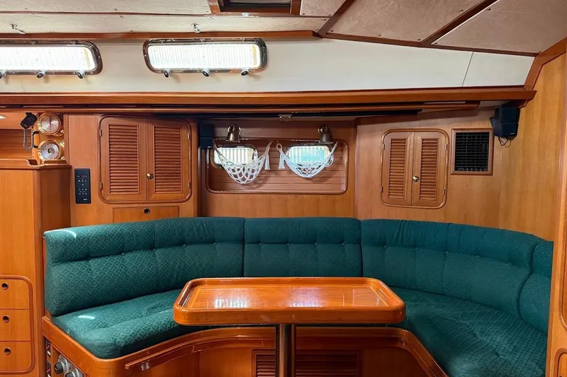 Slide: The Image of Luxurious 1997 Taswell 50 yacht interior with elegant wood finish and plush green seating. - 2